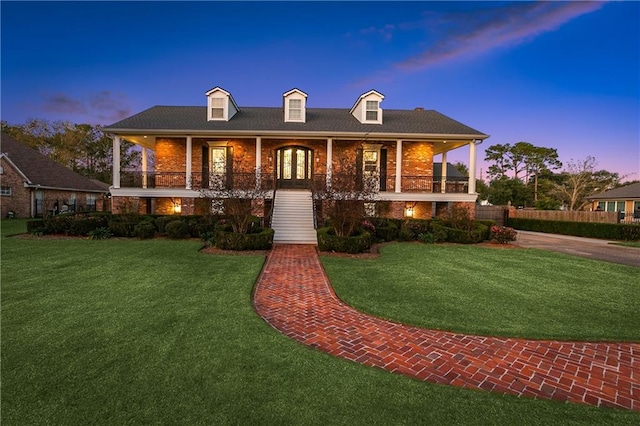 view of front of house featuring covered porch and a yard