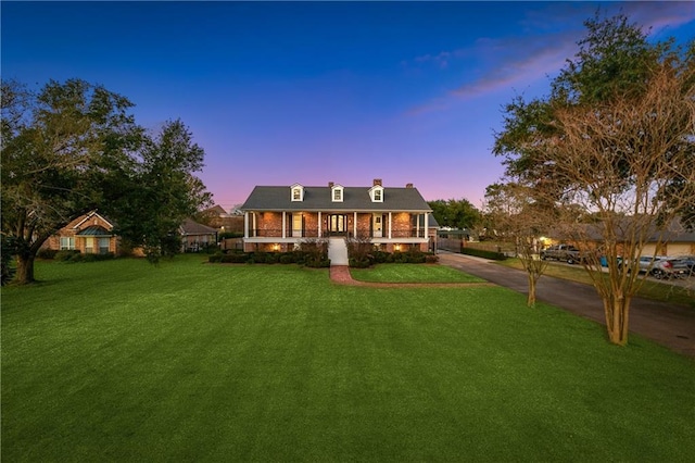 cape cod house with a lawn