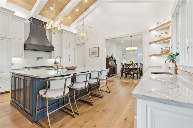 kitchen featuring tasteful backsplash, white cabinetry, and light stone counters