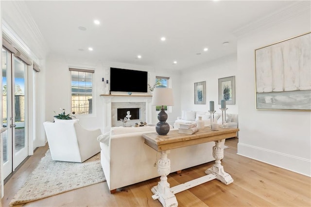 living room featuring french doors, light hardwood / wood-style flooring, and ornamental molding