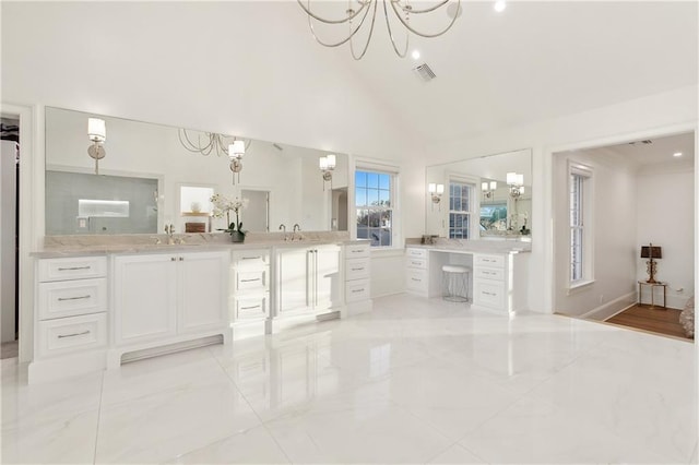 bathroom featuring vanity, high vaulted ceiling, and an inviting chandelier