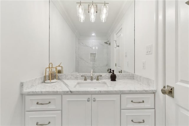 bathroom with vanity, ornamental molding, and tiled shower