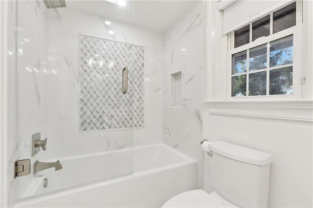 bathroom featuring toilet and tiled shower / bath