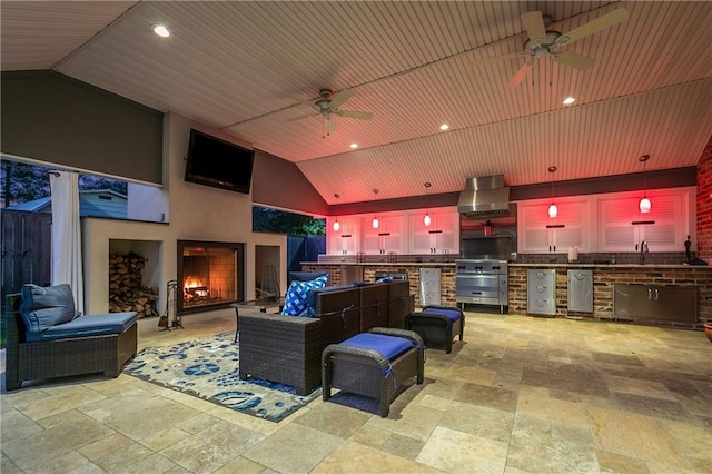 view of patio featuring ceiling fan, grilling area, exterior fireplace, and an outdoor kitchen