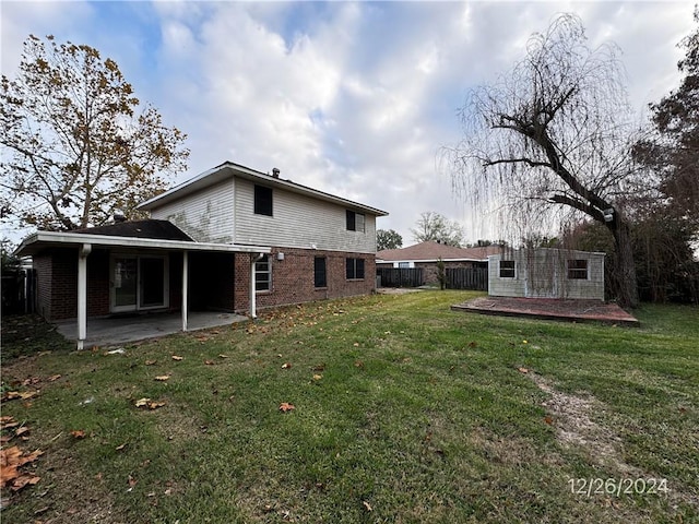 rear view of house with a patio area and a yard