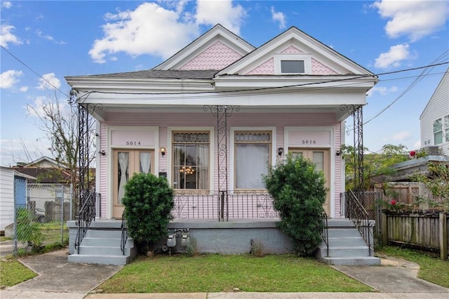 view of front of property with covered porch and a front yard