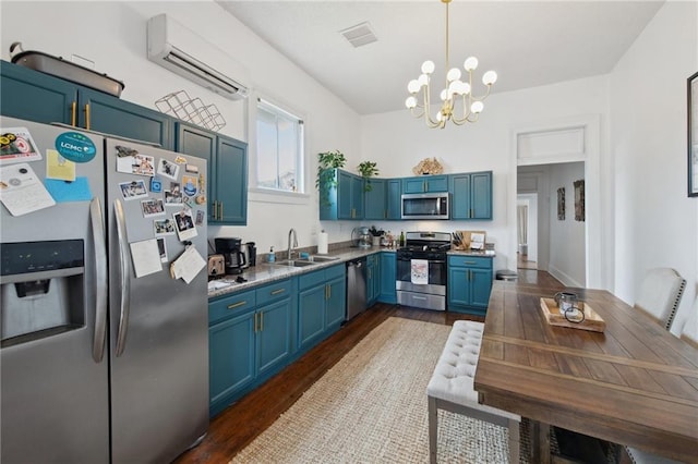 kitchen featuring stainless steel appliances, sink, blue cabinetry, pendant lighting, and an inviting chandelier