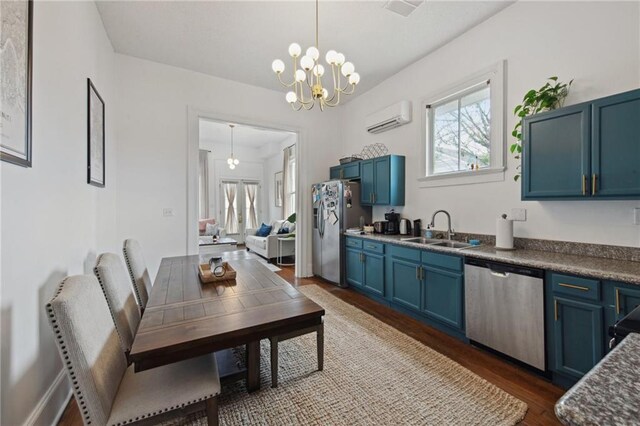 kitchen featuring appliances with stainless steel finishes, blue cabinets, sink, an inviting chandelier, and hanging light fixtures