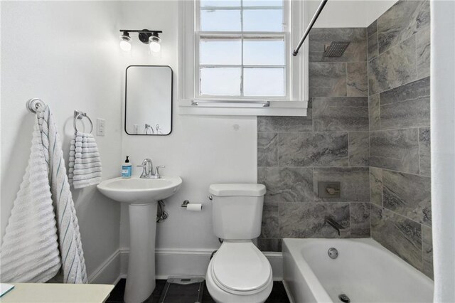 full bathroom featuring toilet, tiled shower / bath, and sink