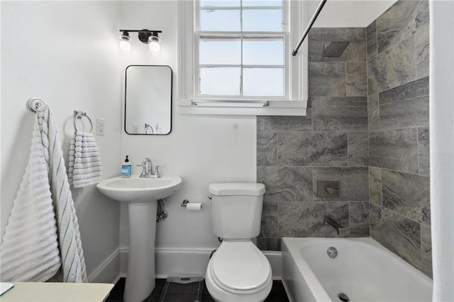 full bathroom featuring toilet, baseboards, tub / shower combination, and a sink