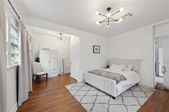 bedroom featuring hardwood / wood-style flooring and a notable chandelier