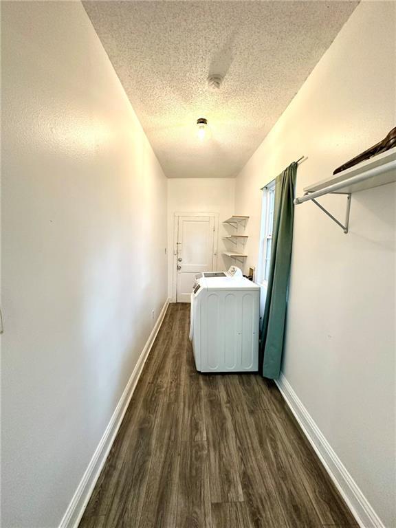 laundry area featuring laundry area, baseboards, washer / clothes dryer, and dark wood finished floors