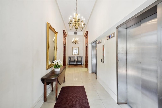 hallway with elevator, light tile patterned floors, and a chandelier