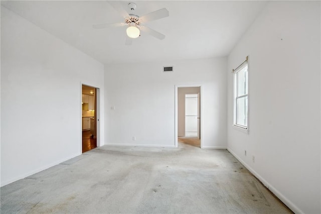 carpeted spare room featuring ceiling fan