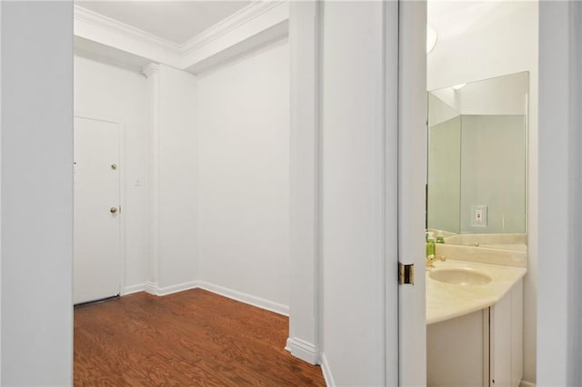 bathroom with hardwood / wood-style floors, vanity, and crown molding