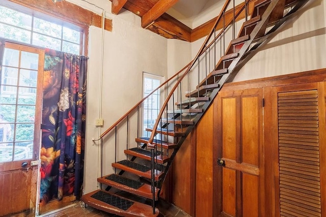 stairs featuring beamed ceiling