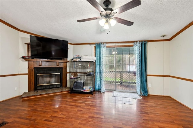 unfurnished living room featuring ceiling fan, crown molding, wood-type flooring, and a textured ceiling