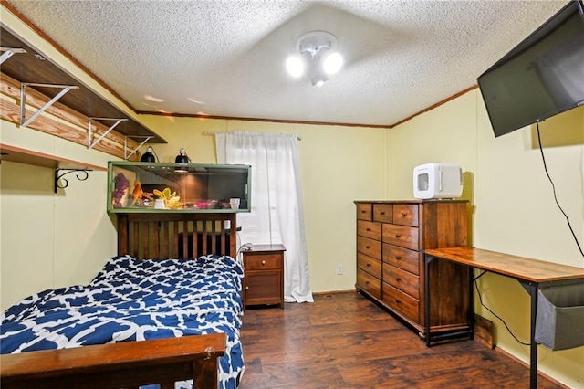 bedroom with a textured ceiling, crown molding, and dark wood-type flooring