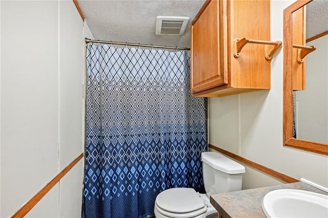 bathroom with vanity, a textured ceiling, and toilet