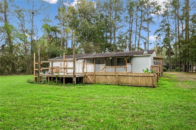 rear view of house featuring a wooden deck and a lawn