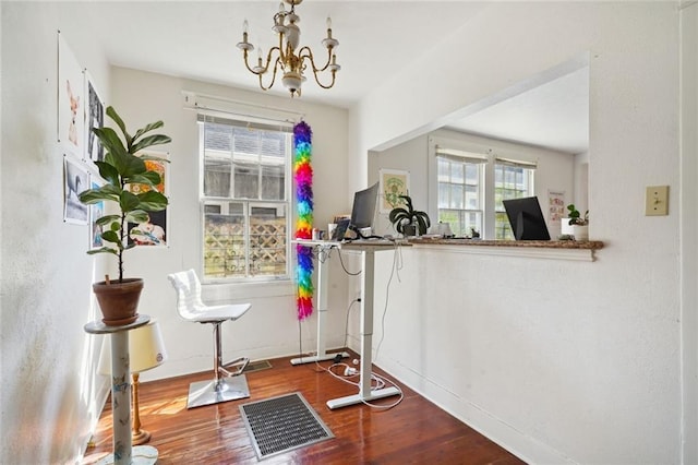 interior space featuring a chandelier, visible vents, baseboards, and wood finished floors