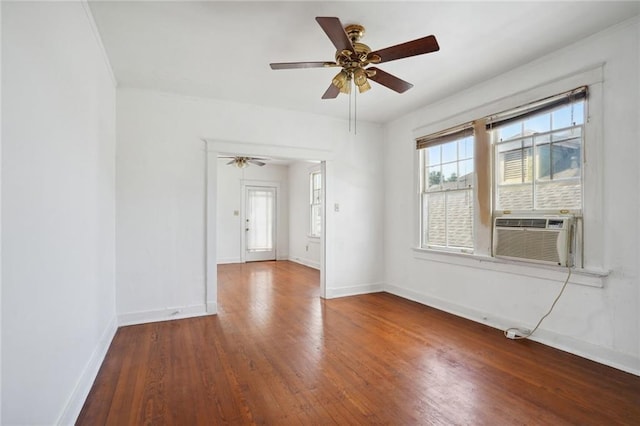 spare room featuring cooling unit, ceiling fan, baseboards, and wood finished floors