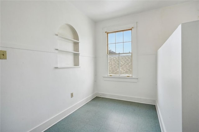 unfurnished room with tile patterned floors and baseboards