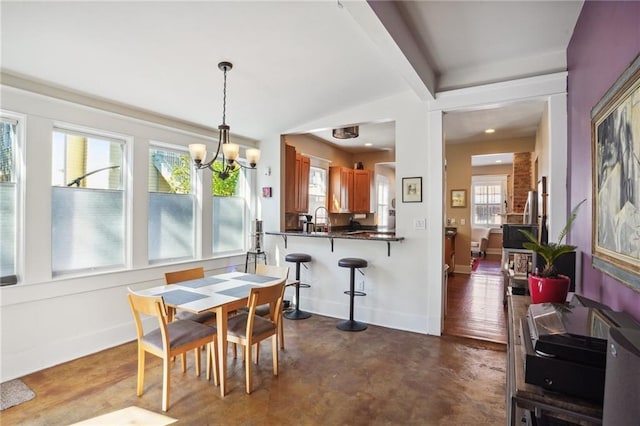 dining space with sink and an inviting chandelier