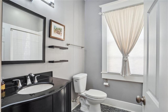 bathroom featuring vanity, toilet, and a shower