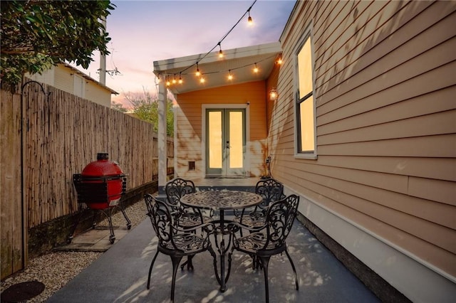 patio terrace at dusk with a grill and french doors