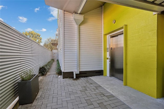 entrance to property with a patio and elevator