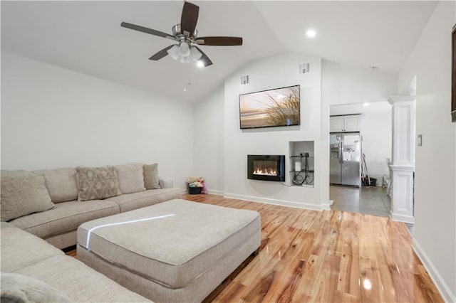 living room with hardwood / wood-style flooring, ceiling fan, and lofted ceiling