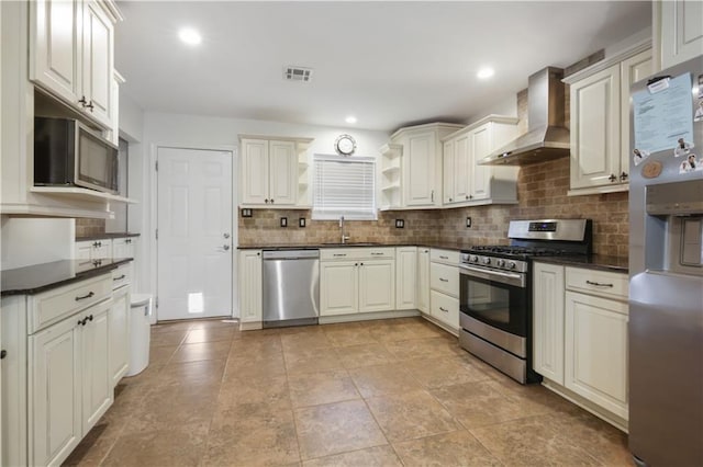 kitchen with tasteful backsplash, sink, stainless steel appliances, and wall chimney range hood