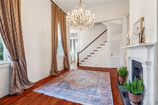 entryway featuring hardwood / wood-style floors, crown molding, and a notable chandelier