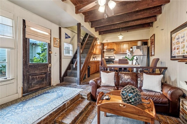 living room with ceiling fan and beamed ceiling