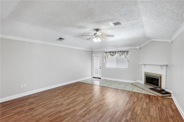 unfurnished living room with lofted ceiling, crown molding, ceiling fan, a textured ceiling, and light hardwood / wood-style floors