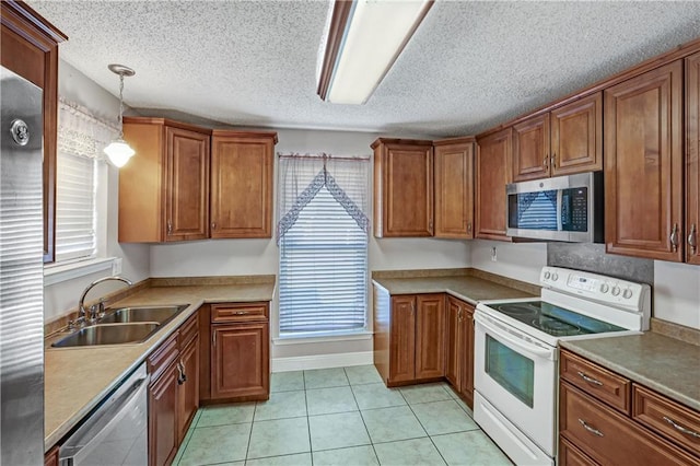 kitchen featuring sink, pendant lighting, plenty of natural light, and appliances with stainless steel finishes