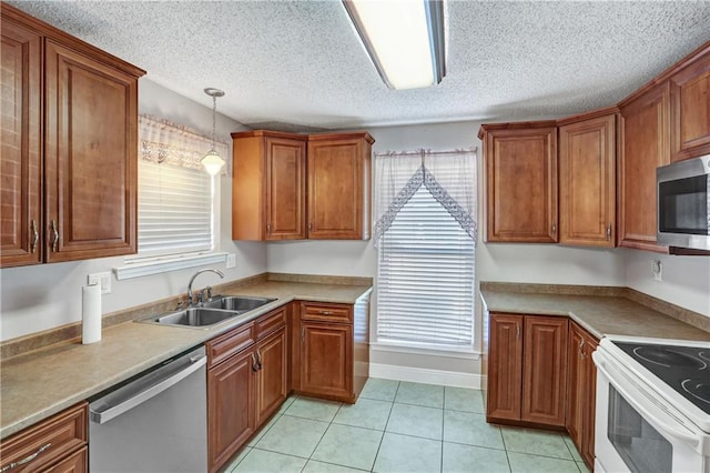 kitchen featuring pendant lighting, stainless steel appliances, light tile patterned floors, and sink