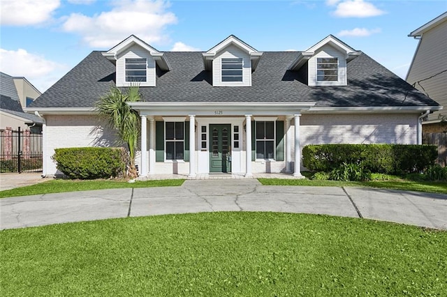 cape cod-style house featuring a front yard