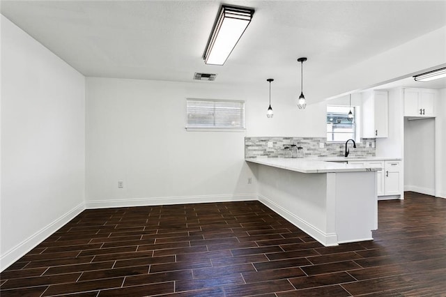 kitchen with white cabinets, a breakfast bar, decorative light fixtures, and kitchen peninsula