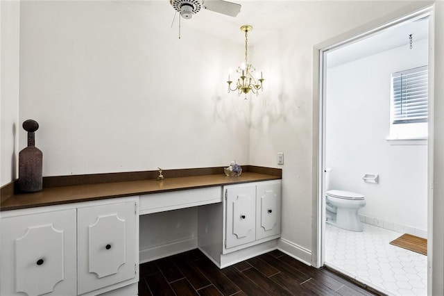 bathroom with ceiling fan with notable chandelier and toilet