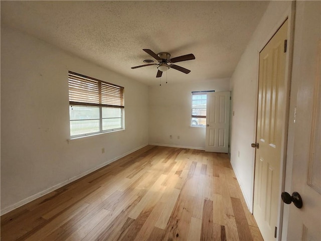 unfurnished room featuring a textured ceiling, light wood-type flooring, and ceiling fan