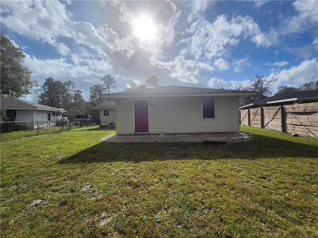 rear view of property featuring a lawn