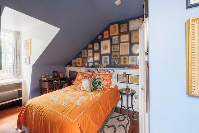 bedroom with hardwood / wood-style flooring and lofted ceiling