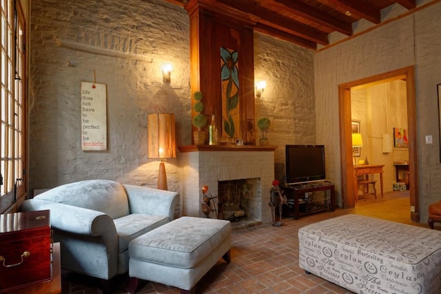 living area with wood ceiling, beamed ceiling, and a fireplace