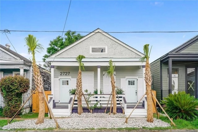 rear view of house featuring covered porch