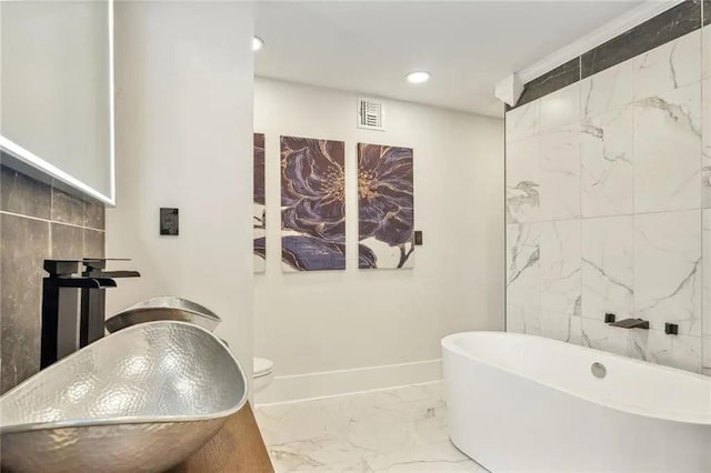 bathroom featuring sink, a bathtub, and toilet