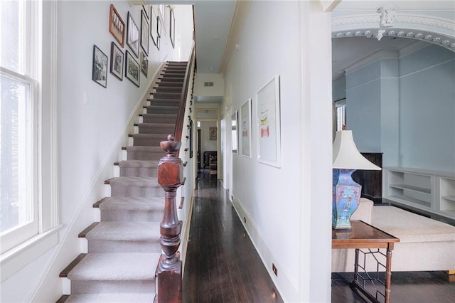 stairs featuring wood-type flooring and ornamental molding