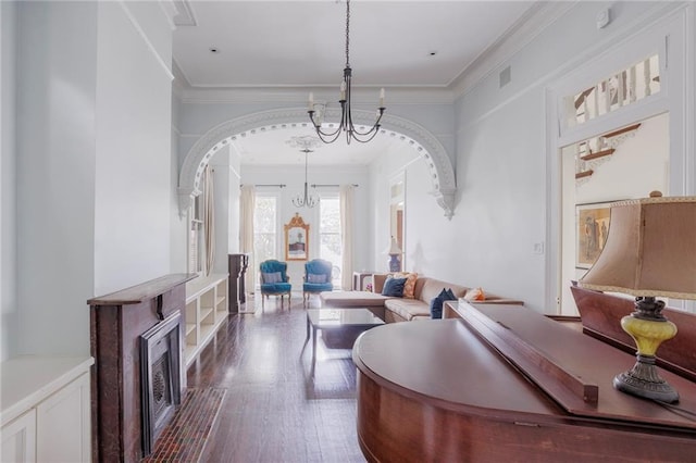 living room featuring hardwood / wood-style floors, ornamental molding, and a notable chandelier