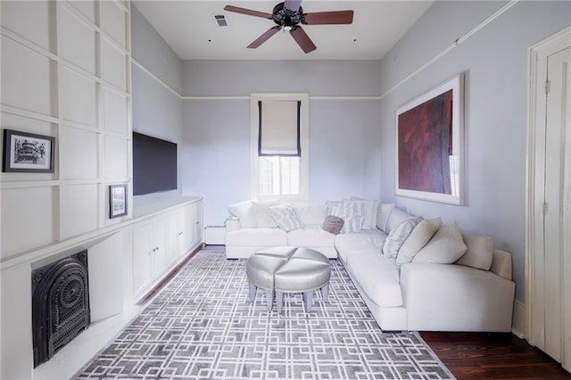 living room with dark hardwood / wood-style flooring and ceiling fan